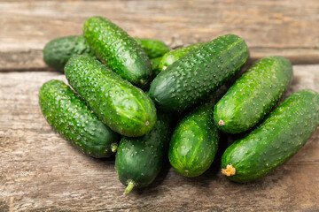Cucumber on wooden background. Slice of cucumber on background. Fresh organic green cucumbers gherkin. Vegan. Salad ingredient. Farm vegetables. Cut vegetables with knife. Space for text. Copy space
