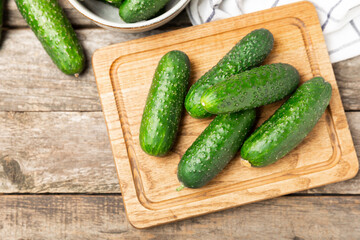 Cucumber on wooden background. Slice of cucumber on background. Fresh organic green cucumbers gherkin. Vegan. Salad ingredient. Farm vegetables. Cut vegetables with knife. Space for text. Copy space