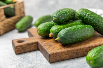 Cucumber on wooden background. Slice of cucumber on background. Fresh organic green cucumbers gherkin. Vegan. Salad ingredient. Farm vegetables. Cut vegetables with knife. Space for text. Copy space