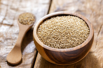 A pile of quinua grains is seen in the image, in a wooden container