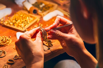 Artisan hands crafting fine gold jewelry using detailed tools in workshop