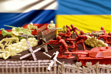Naklejka premium Battle against the background of Russian and Ukrainian flags. Miniature soldiers from opposite sides depict an armed conflict surrounded by barricades, barriers and equipment.