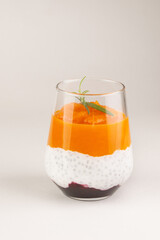 Sweet сhia pudding raw dessert with  pumpkin or mango in glass on white background, isolated