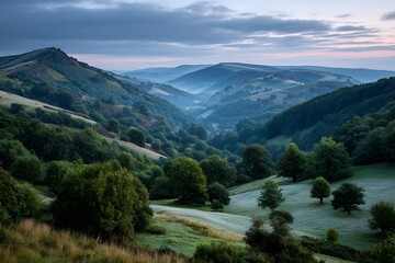 Naklejka premium Lush green hills and trees creating a serene, harmonious landscape at dawn, as soft light highlights the peaceful beauty of nature's untouched wonder.
