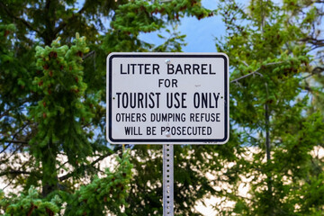 Fototapeta premium Sign mentioning that a litter barrel is for tourist use only on the east shore of the Kootenay Lake in British Columbia, Canada