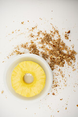 a vibrant pineapple ring nestled in a white bowl, surrounded by scattered walnuts, evoking a sense of natural sweetness and healthy snacking. Ideal for food blogs, healthy lifestyle content