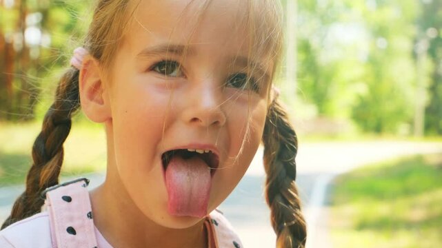 Close up of a preschool girl face grimacing outdoor