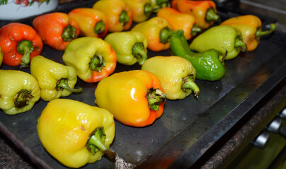 ripe bell peppers laid out on a baking sheet and ready to be baked in the oven. cooking vegetables. ingredient for the main course. vitamins. diet food