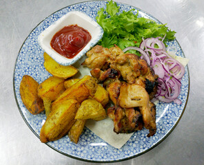 chicken shashlik with potato wedges and ketchup. served with pickled onions and herbs. healthy and dietary nutrition. tasty and healthy food. protein and vitamins