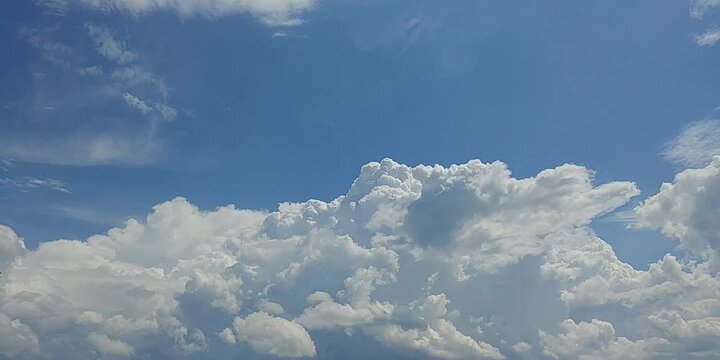 Natural blue sky with moving white clouds Cumulus, Cumulonimbus calvus and Cumulus congestus on sunny and stormy summer weather - timelapse. Topics: heaven, cloudscape, meteorology, beauty of nature