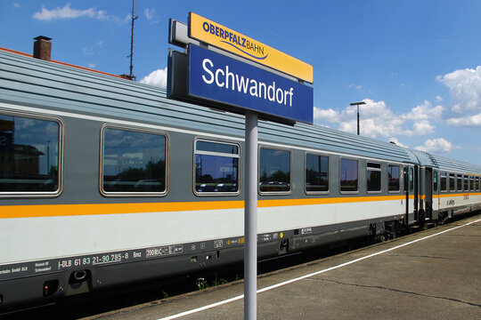 Schwandorf, Germany - May 31, 2025: Oberpfalzbahn platform sign with modern regional train on a bright summer day at Schwandorf station, Bavaria