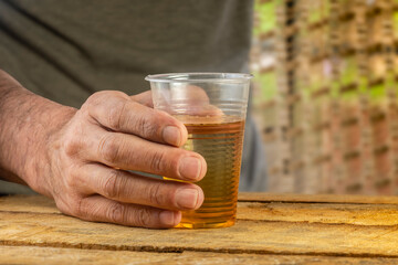 Close-up of a hand holding a glass of beer