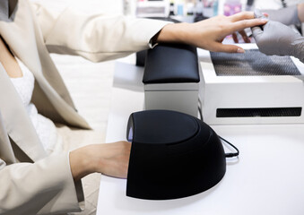 master applying gel polish on women nails in beauty salon. manicurist is polishing with file drill...