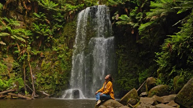 Woman seated by Beauchamp Falls in Great Otway National Park