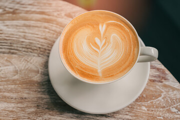 Freshly Brewed Coffee with Heart Latte Art on Wood Table in Cozy Café Setting