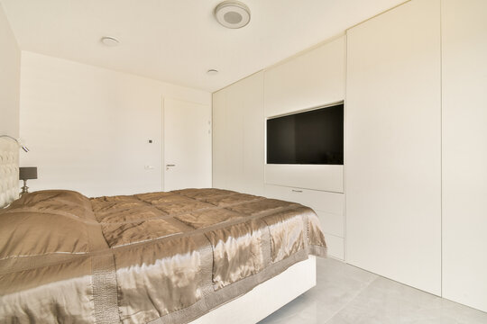 Modern bedroom with cozy brown bedding and built-in TV