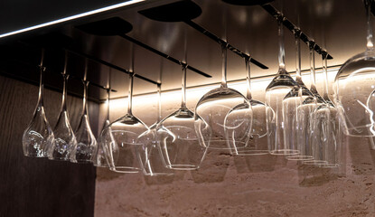 Hanging wine glasses under the shelf with warm accent lighting