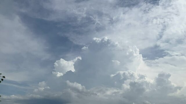 Natural blue sky with moving white clouds Cumulus, Cumulonimbus calvus, Cumulonimbus capillatus and Cumulus congestus on sunny and stormy summer weather - timelapse. Topics: cloudscape, meteorology