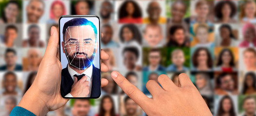 A hand holds a smartphone displaying a man face with digital facial recognition lines overlaid.