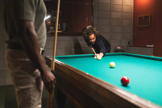 Men playing pool in a coworking space - Powered by Adobe