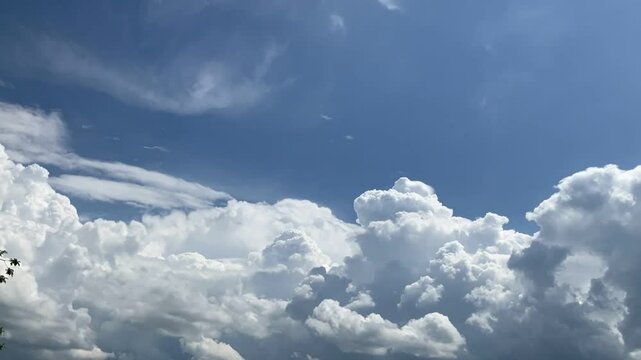 Natural blue sky with moving white clouds Cumulus, Cumulonimbus calvus, Cumulonimbus capillatus and Cumulus congestus on sunny and stormy summer weather - timelapse. Topics: cloudscape, meteorology