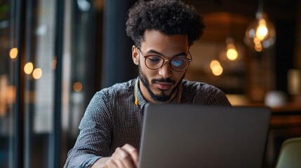 Focused young man working on a laptop in a cafe.