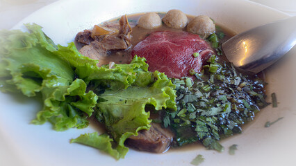 An isolated close-up showcases a delicious bowl of Wagyu beef noodle soup, featuring tender beef slices, meatballs, and green vegetables in a rich, thick broth, perfect for lunch