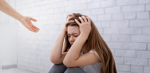 Support and care for people with mental problems. Psychologist hand helping sad lonely young woman...