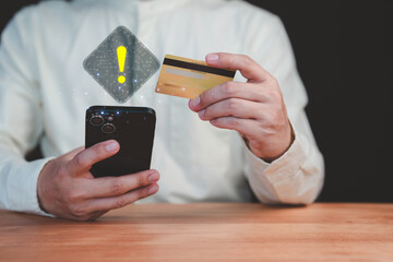 Adult man holding a credit card and mobile phone with a warning sign overlay, symbolizing online scams, fraud, security risks, transfer money and financial caution in digital transactions.