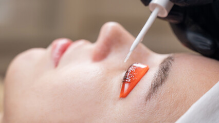 Caucasian woman undergoing eyelash lamination procedure. 