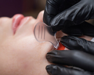 Caucasian woman undergoing eyelash lamination procedure. 