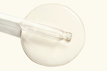 Cosmetic yellow beige serum or ampoule, gel swatch with pipette dropper isolated on beige