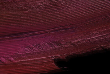 Pink matte or satin finish smeared lipstick background texture smudge isolated on black. Make up...