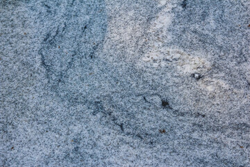 Detailed macro shot of blue-gray granite stone surface displaying natural mineral patterns and crystalline structure