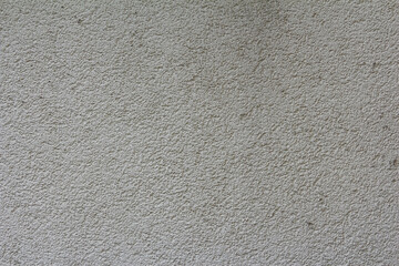 A close-up view of a uniformly textured, light brown or beige wall surface with a subtle granular pattern.