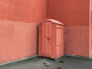 Portable public restroom. Chemical toilet cabine around corner. Painted Funny bio toilet or porta...