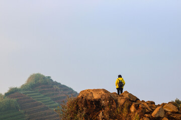 Climbers on the rock of Sikunir Hill, Dieng