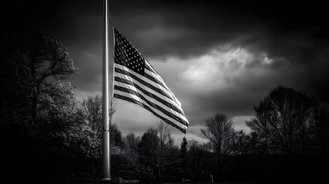 A somber American flag at half-mast flies against a dramatic stormy sky above a peaceful cemetery landscape. - Powered by Adobe