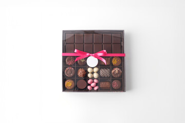 assorted chocolate box with pink ribbon top view on white background perfect for gift packaging design mockup product photo for confectionery branding bakery e commerce greeting card or poster