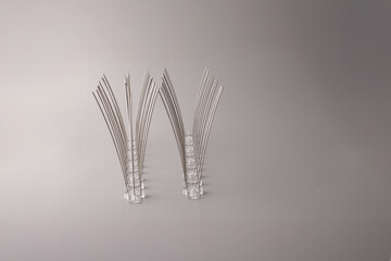 Two rows of anti-pigeon spikes with metal rods and transparent bases for rooftop and ledge...