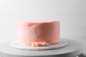 piping border on Pink buttercream cake on a cake plate, Cake covered in pink frosting, process of...
