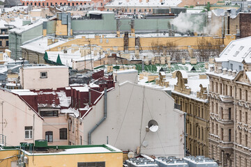 Old buildings roofs under the snow.