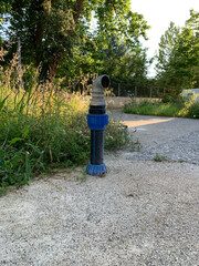 Fire hydrant on concrete pad, made of metal and plastic, with curved spigot for fire hose...