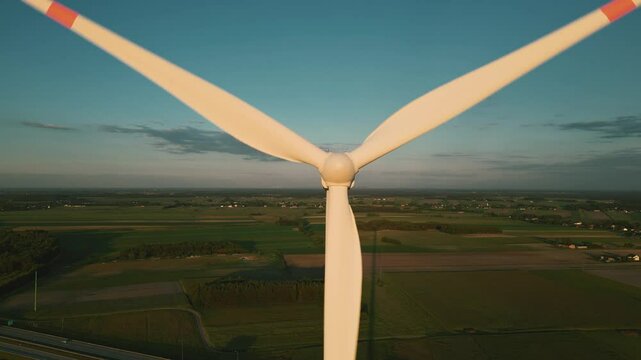 Aerial drone shot of a wind turbine at sunset, symbolizing clean and renewable energy in harmony with nature