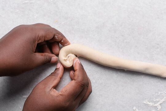 Overhead view of rolled paratha dough on a marble countertop, top view of flaky flatbread dough, process of making paratha