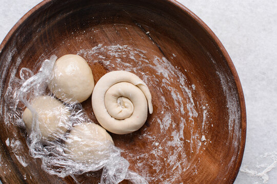 Overhead view of rolled paratha dough, top view of flaky flatbread dough, process of making paratha