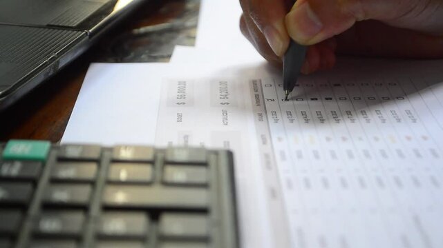 To-Do List and Task List Concept. Close-up businessman checks or marks with pen on a checklist, checkbox, to-do list box after completing a task on a white paper. 
Checking boxes with a pen 