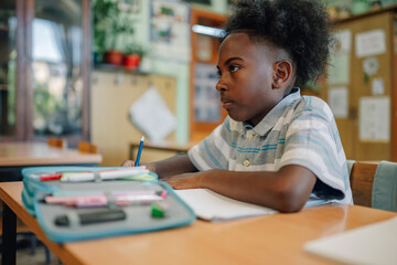 Elementary school student taking notes during class
