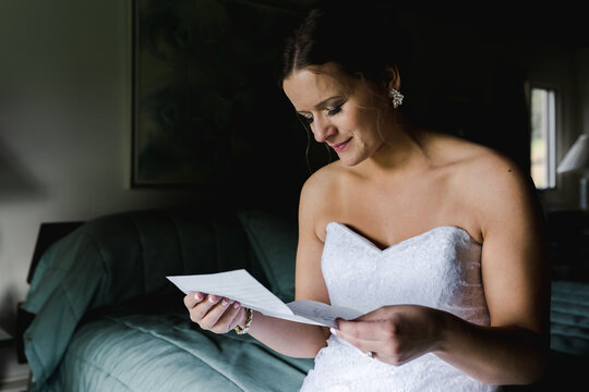bride reading a sweet  letter from groom  before wedding