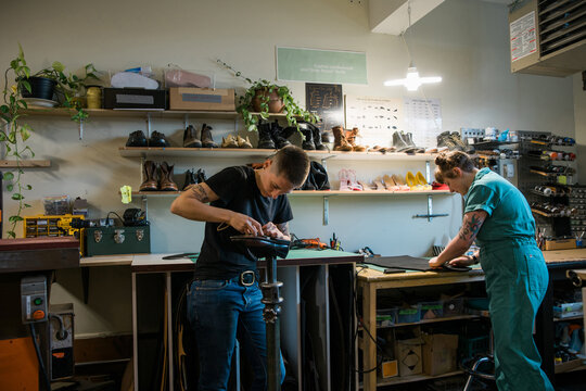 Two people working in a shoe repair shop.